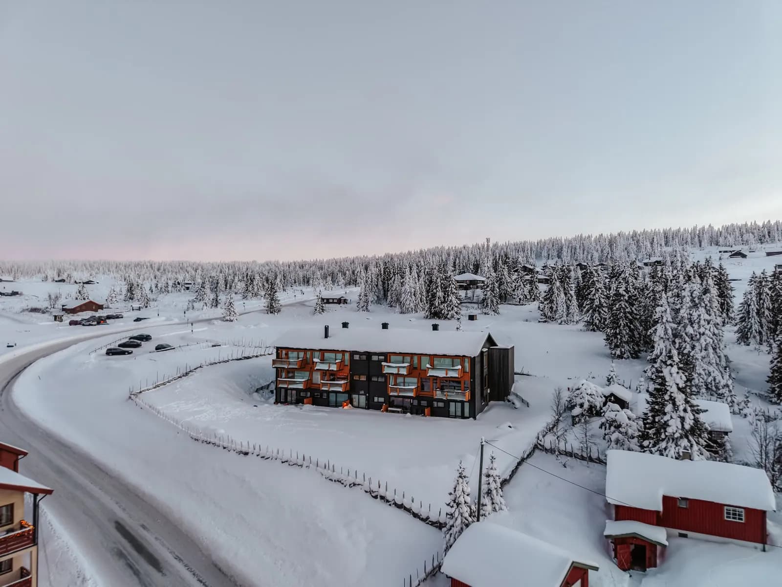 Dronebilde av bygget på Nordseter en vintermorgen, med skiløypa forbi