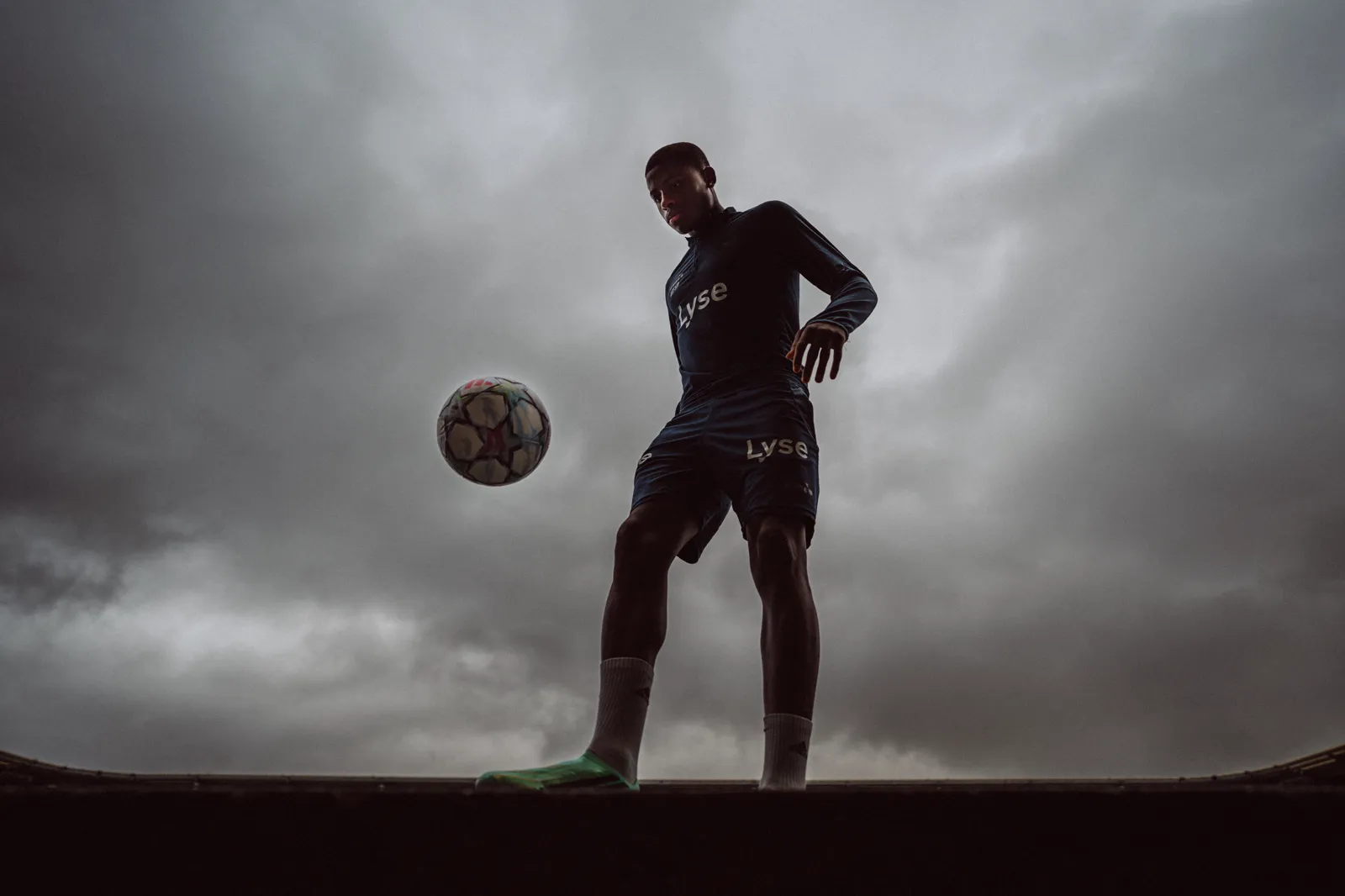 Tobias Moi i silhuett mot en grå himmel, med ballen i lufta