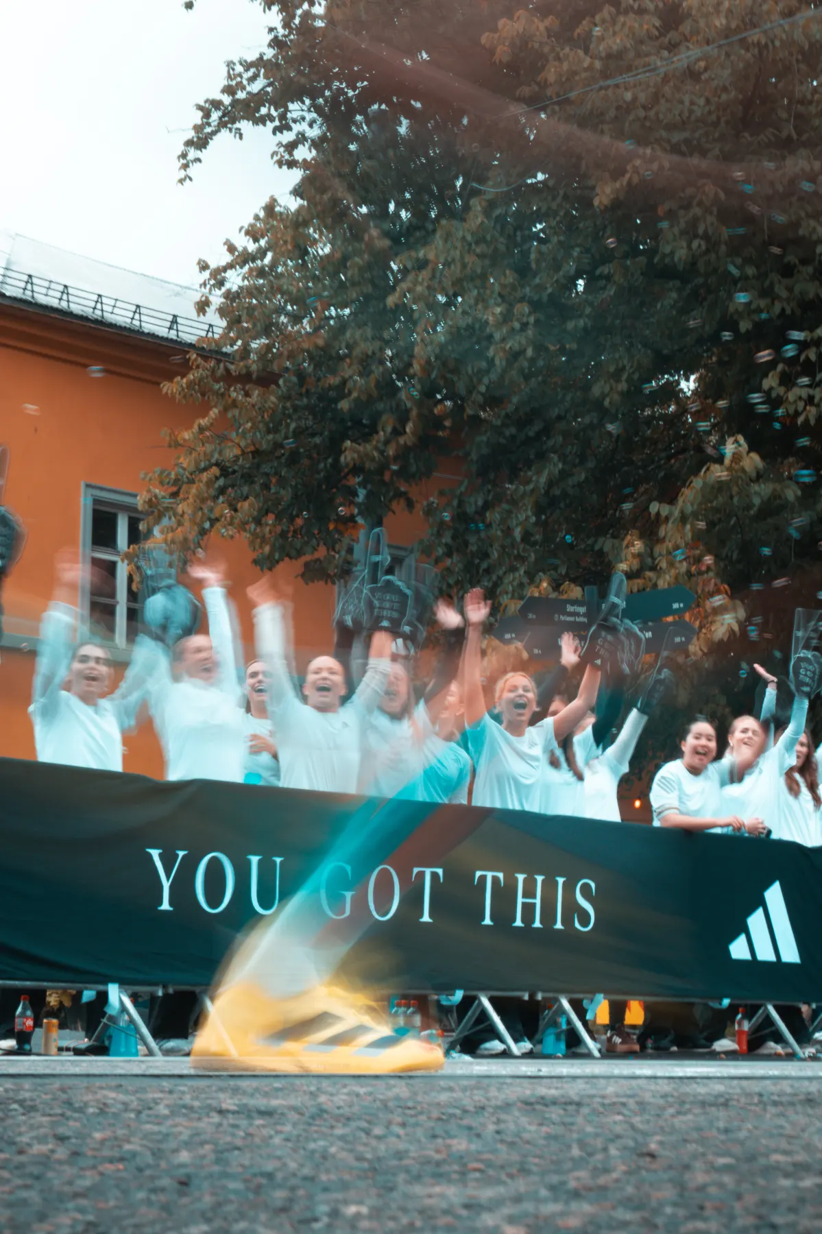 Heiagjengen bak gjerdet med You got this-banner