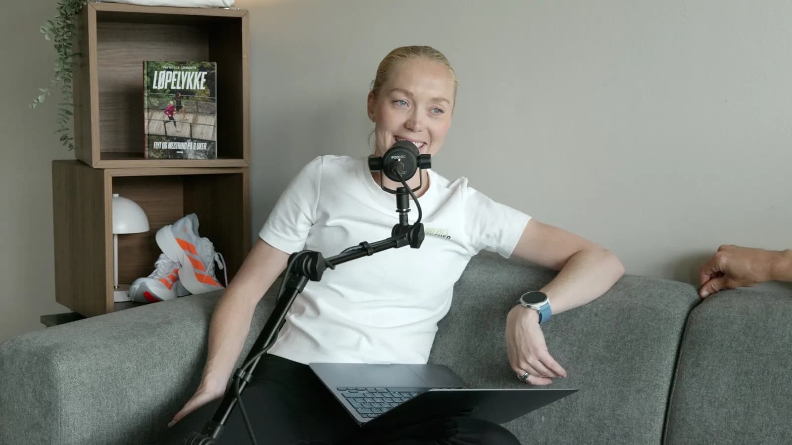 Veronica Undseth i sofaen med mikrofon under et podkastopptak